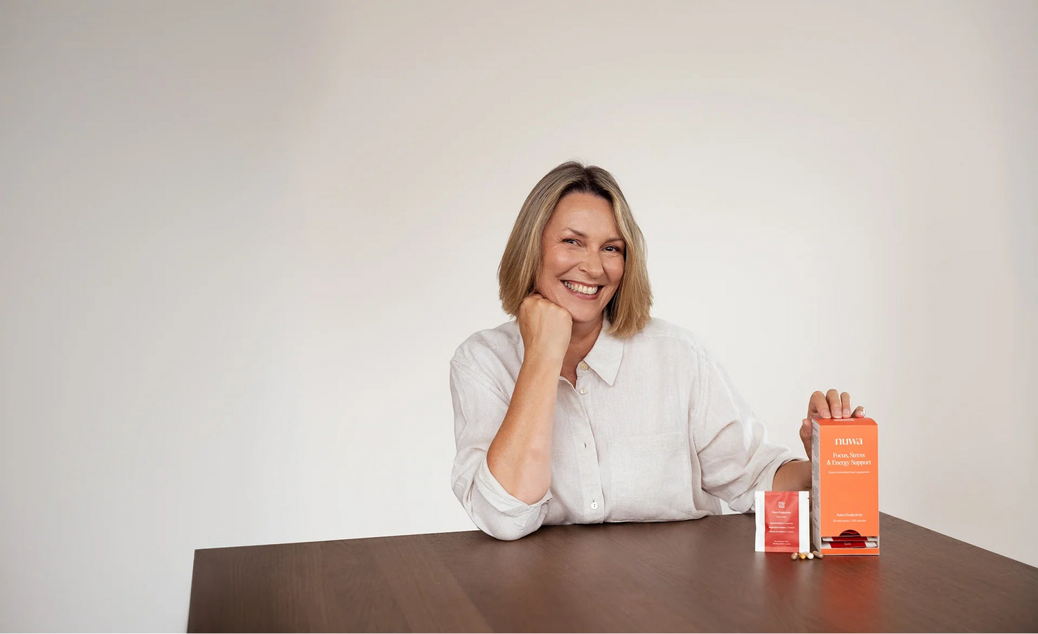 Model smiling at a desk with Nuwa supplements