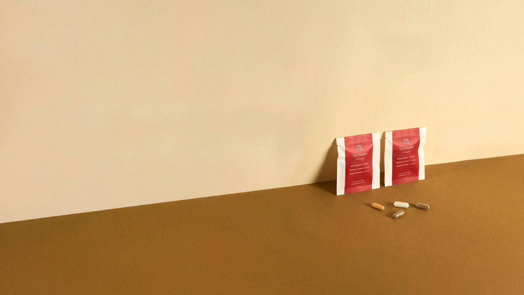Nuwa sachets laying against wall with 4 capsules